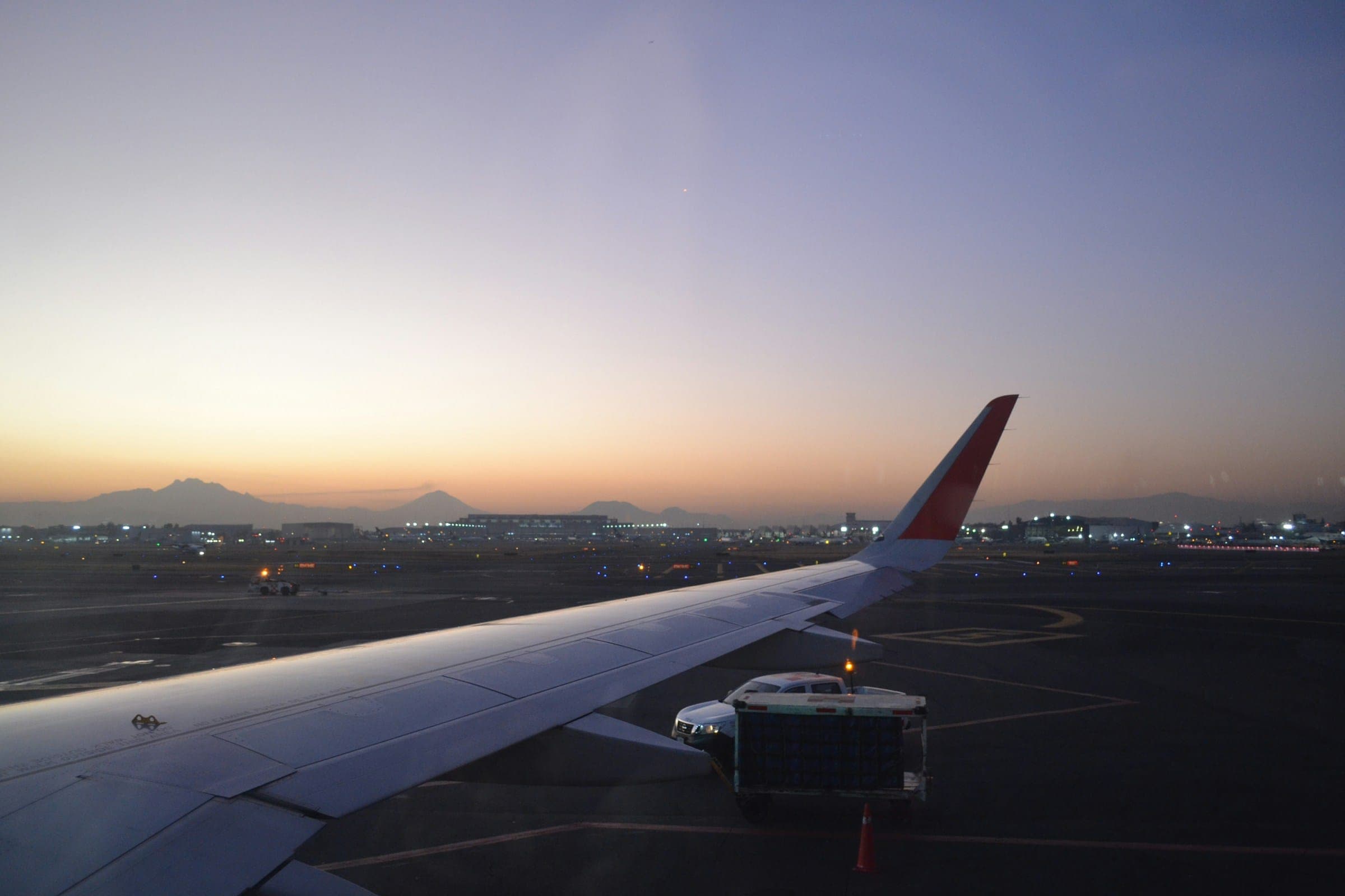 Vliegtuigvleugel op een luchthaven bij zonsondergang